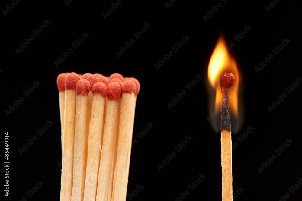 Group of red wooden matches standing with burning match Group of red wooden matches standing with burning match