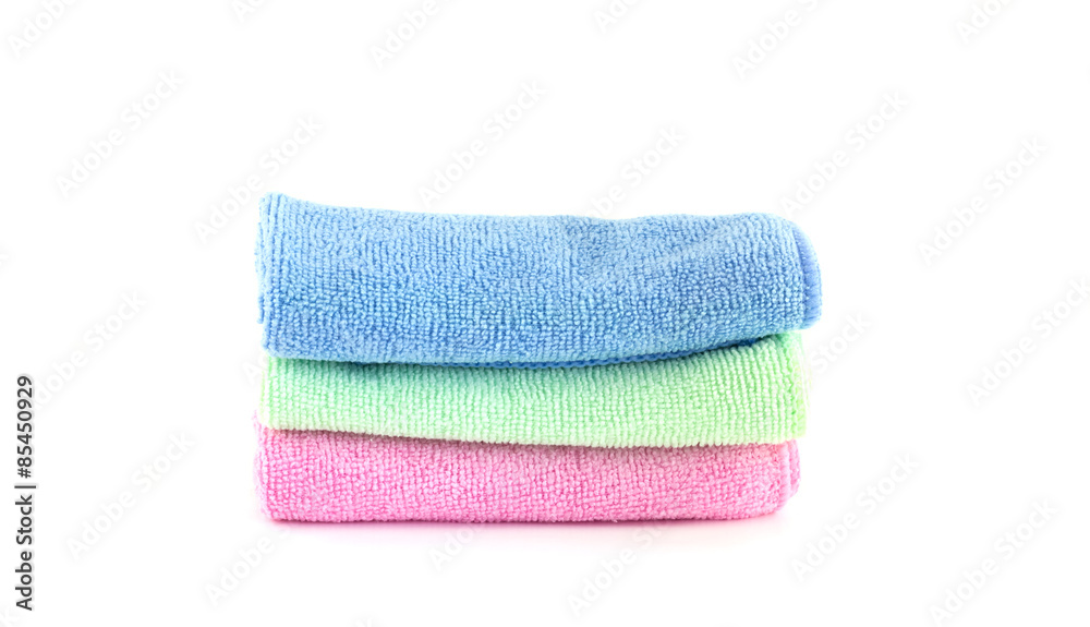 Pink, blue and green towels roll horizontally on a white backgro Pink, blue and green towels roll horizontally on a white backgro