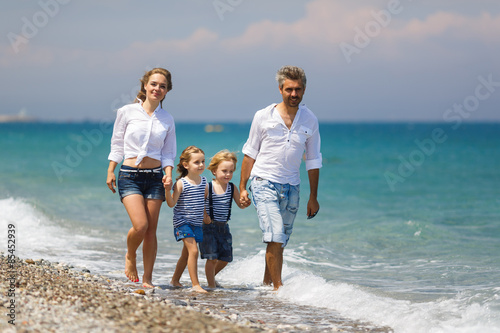 Family with two kids on the beach © castenoid