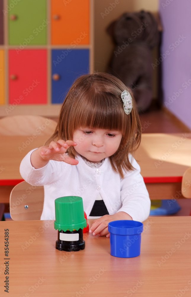 Two-year girl playing and learning in preschool Two-year girl playing and learning in preschool