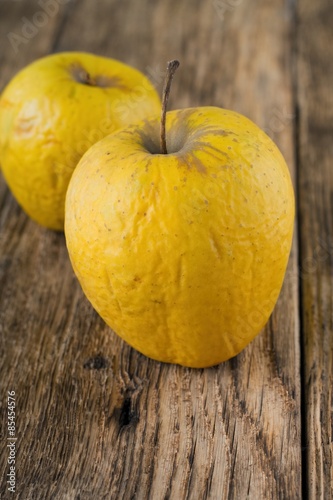 Couple of overriped apples on wooden board
