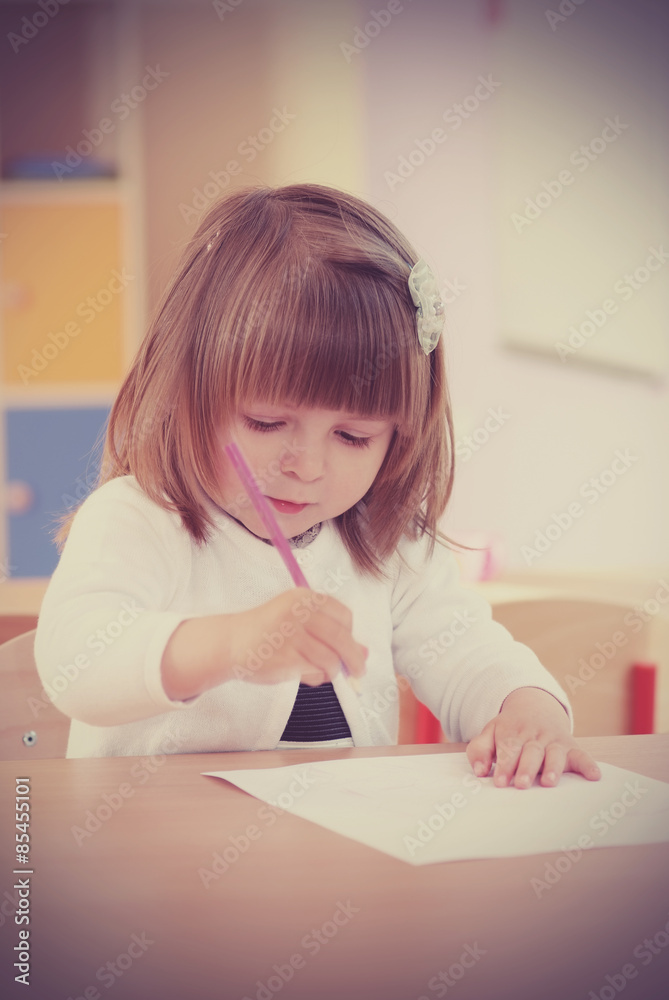 Two-year girl playing and learning in preschool Two-year girl playing and learning in preschool