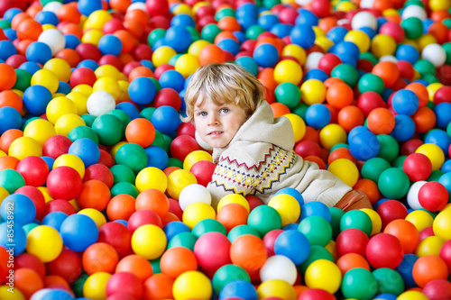 child playing at colorful plastic balls playground