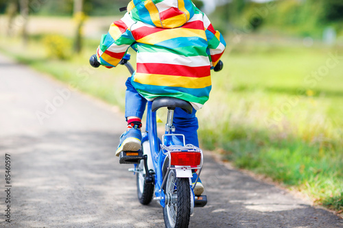 Little child in colorful clothes on bicycle