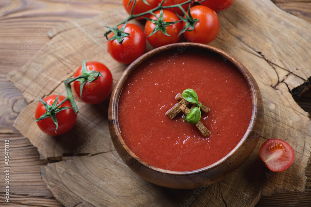 Gazpacho soup served with croutons in a wooden bowl, studio shot