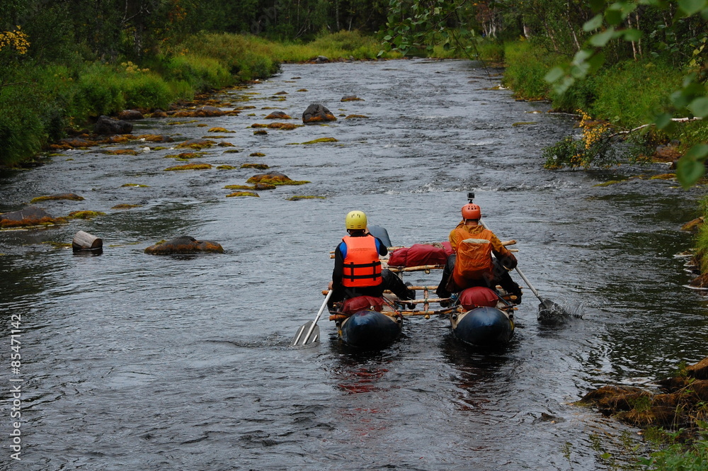 Two men on a catamaran raft down the taiga river. Two men on a catamaran raft down the taiga river.