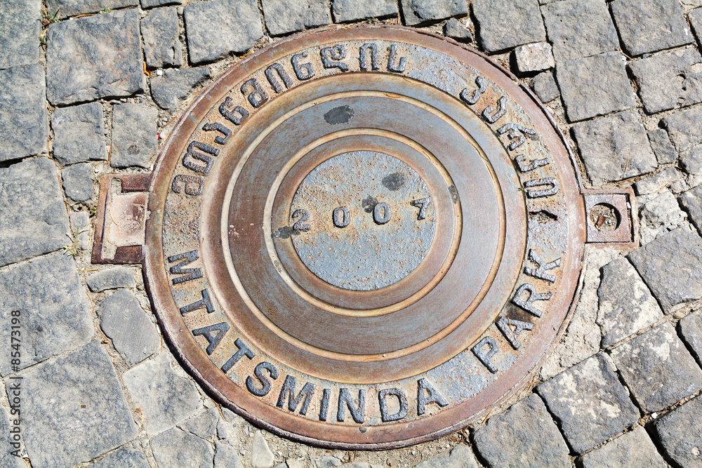 Manhole on cobblestone road. Tbilisi. Georgia