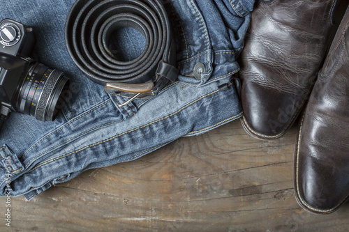Vintage Kamera, Jeans, Leather Boots and Belt on wooden Background © kunertus