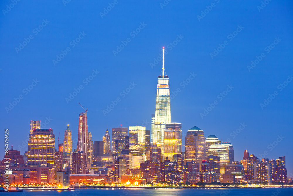 New York City skyline of financial business buildings in Manhattan illuminated at night
