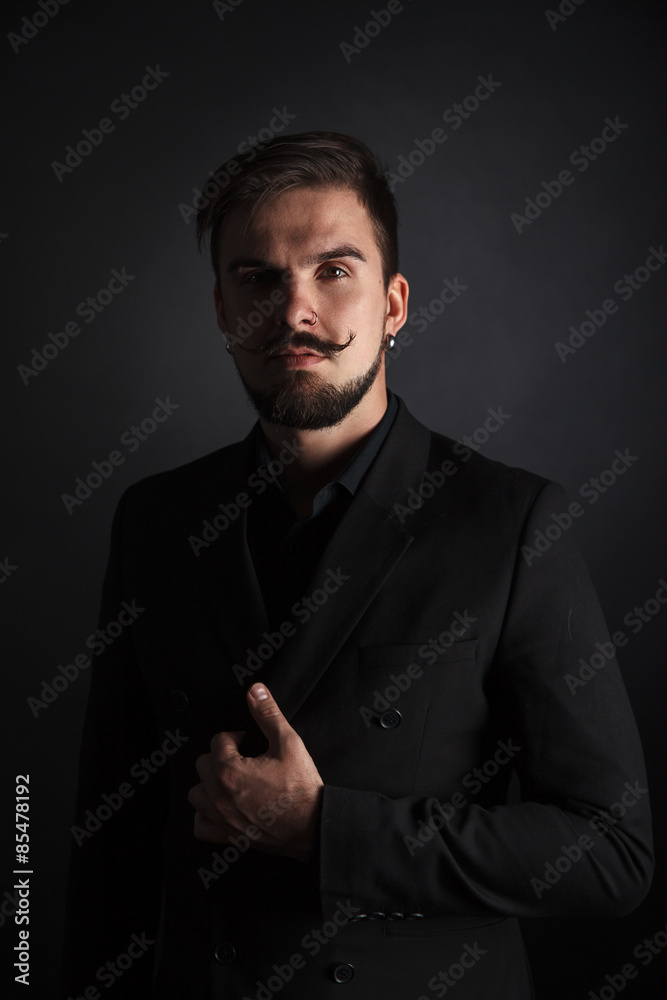 handsome brutal guy with beard on dark background