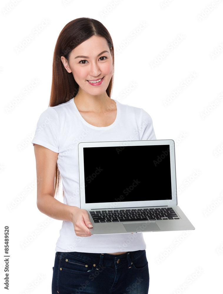 Naklejka premium Young woman show with the blank screen of laptop computer