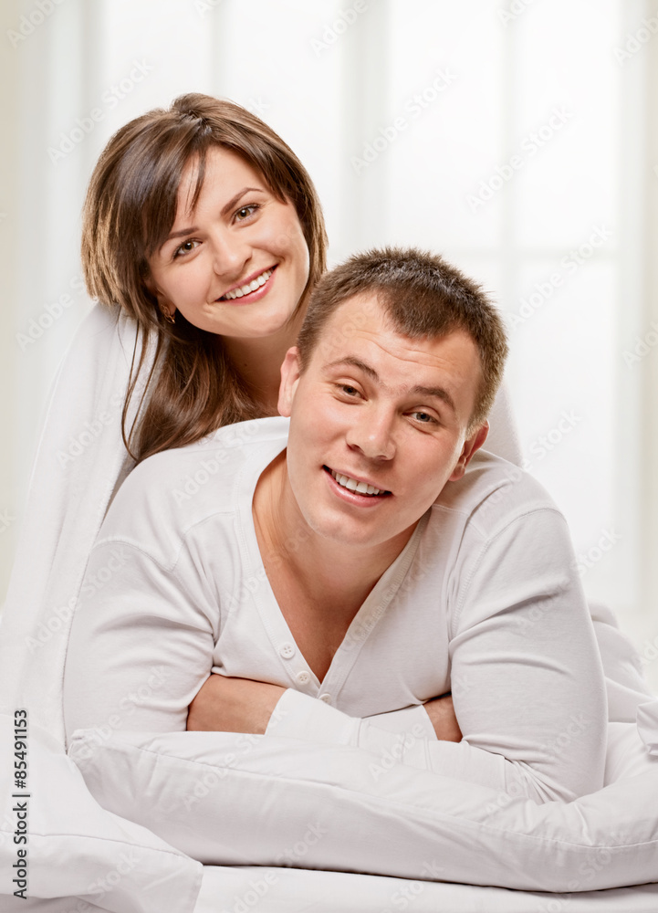 Couple lying in bed smiling Couple lying in bed smiling