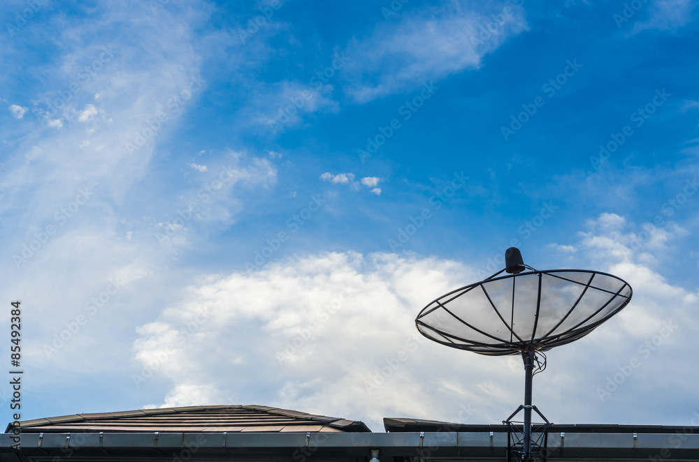 A black satellite dish on blue sky background