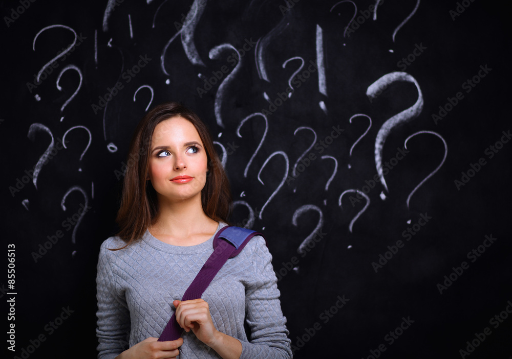Young girl with question mark on a gray background Young girl with question mark on a gray background