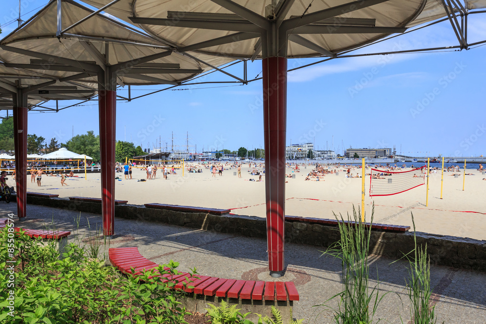 Fototapeta premium Gdynia - Bulwar Nadmorski i plaża nad Bałtykiem. W tle widać port jachtowy i molo południowe.