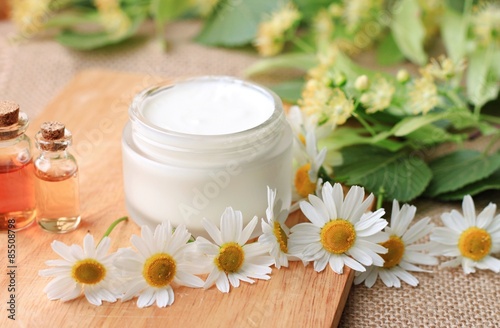 jar of natural organic cream cosmetic product fresh flowers chamomile linden herbs  essential oils spa