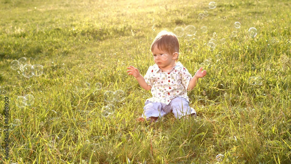 Baby sitting on the grass in a soap bubbles. Baby sitting on the grass in a soap bubbles.