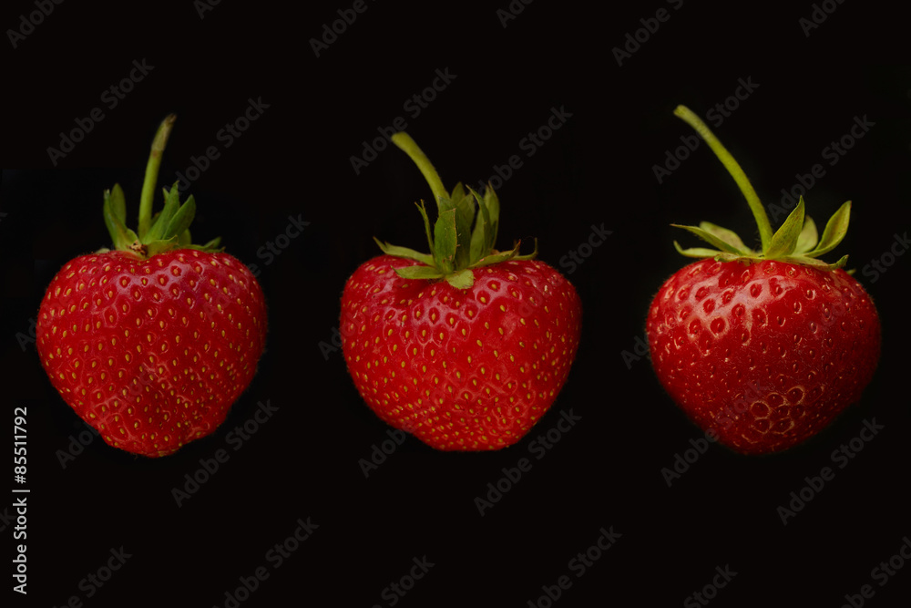 three strawberries on black background three strawberries on black background