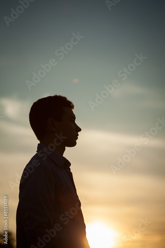 Silhouette of boy on sea sunset