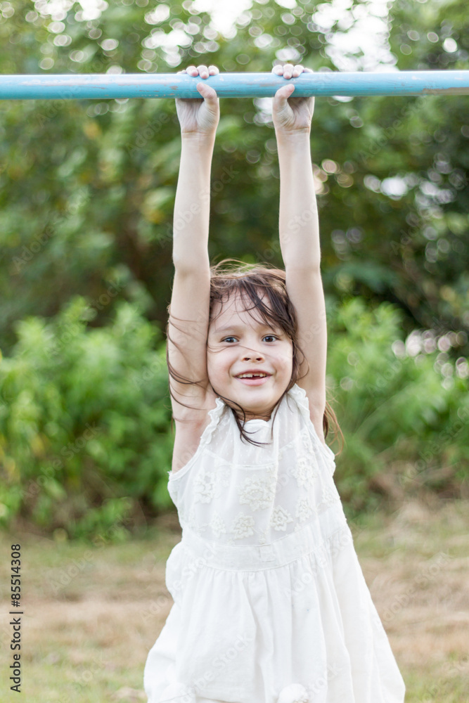 Young girl hanging on bar