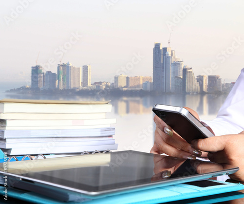 Touch screen mobile phone  in hand woman waiting something with big city background