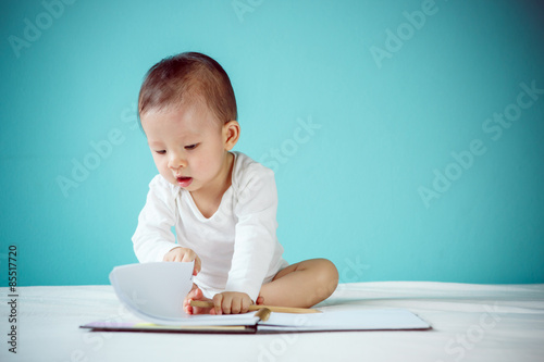 Asian baby writing in a book