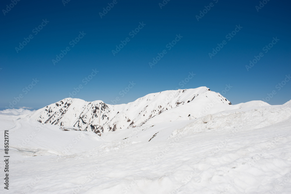 Snow covered hill and blue sky at Tateyama alpine route, Toyama Prefecture