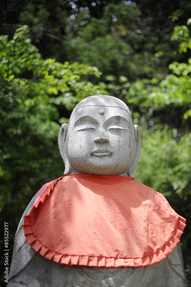 Stone statue and green leaves, Iwate Prefecture, Japan