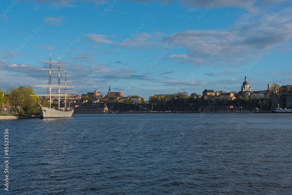 Sailing ship is in foreground of Skeppsholmen islands at evening, Stockholm, Sweden.