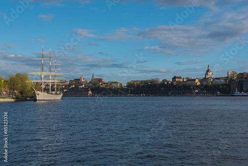 Sailing ship is in foreground of Skeppsholmen islands at evening, Stockholm, Sweden.