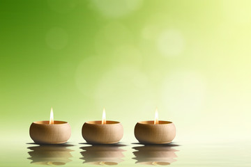 Spa concept. Three candles on green background.