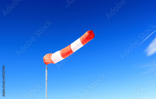 Red windsock in front of deep blue sky.