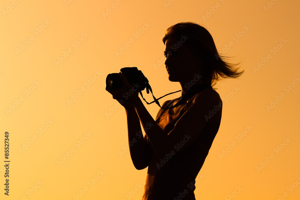 Silhouette of a woman photographing.