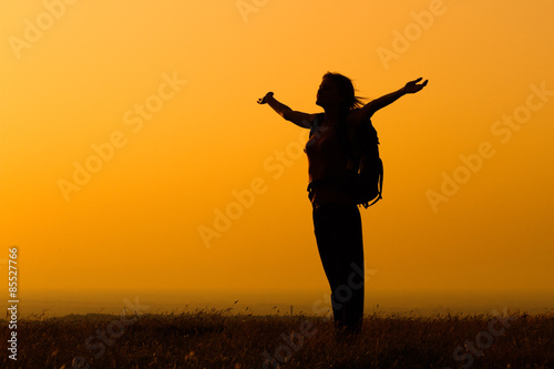 Woman hiker greeting the sunset