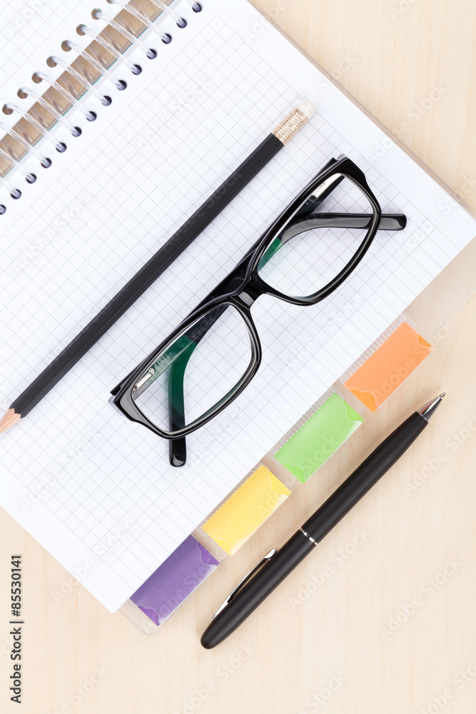 Office table with glasses, blank notepad and pencil Office table with glasses, blank notepad and pencil