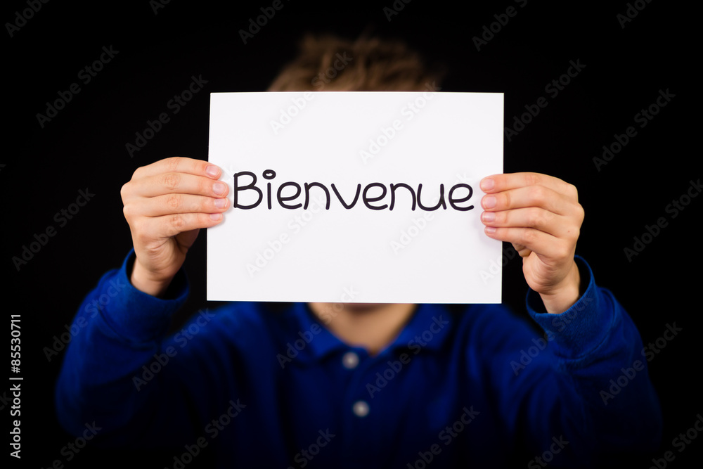 Child holding sign with French word Bienvenue - Welcome Child holding sign with French word Bienvenue - Welcome