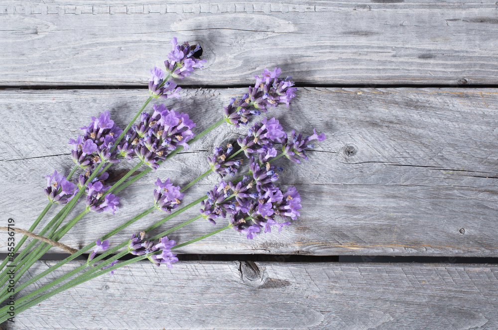 Fototapeta premium Bouquet of purple lavenders against wooden background