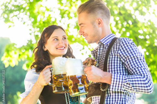 Deutsches Paar in Tracht trinkt Bier