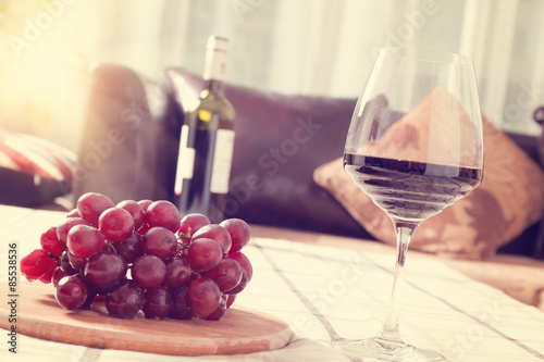 Red Wine in Glass with Grapes on The Table