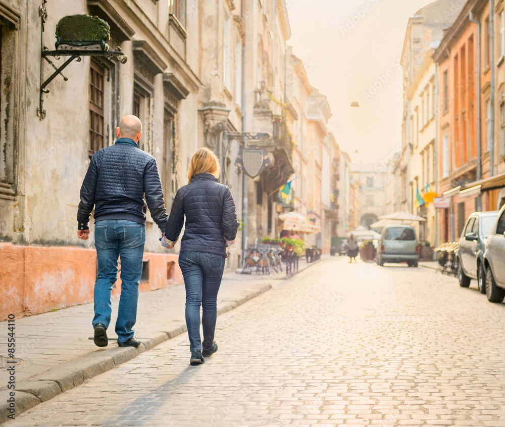Young fashion elegant stylish couple walk  on streets of european city in summer morning