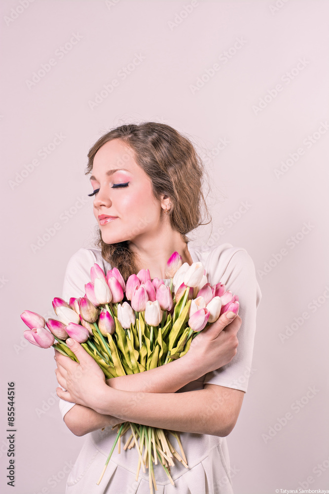 girl hugging on a white background of tulips on a white backgrou girl hugging on a white background of tulips on a white backgrou