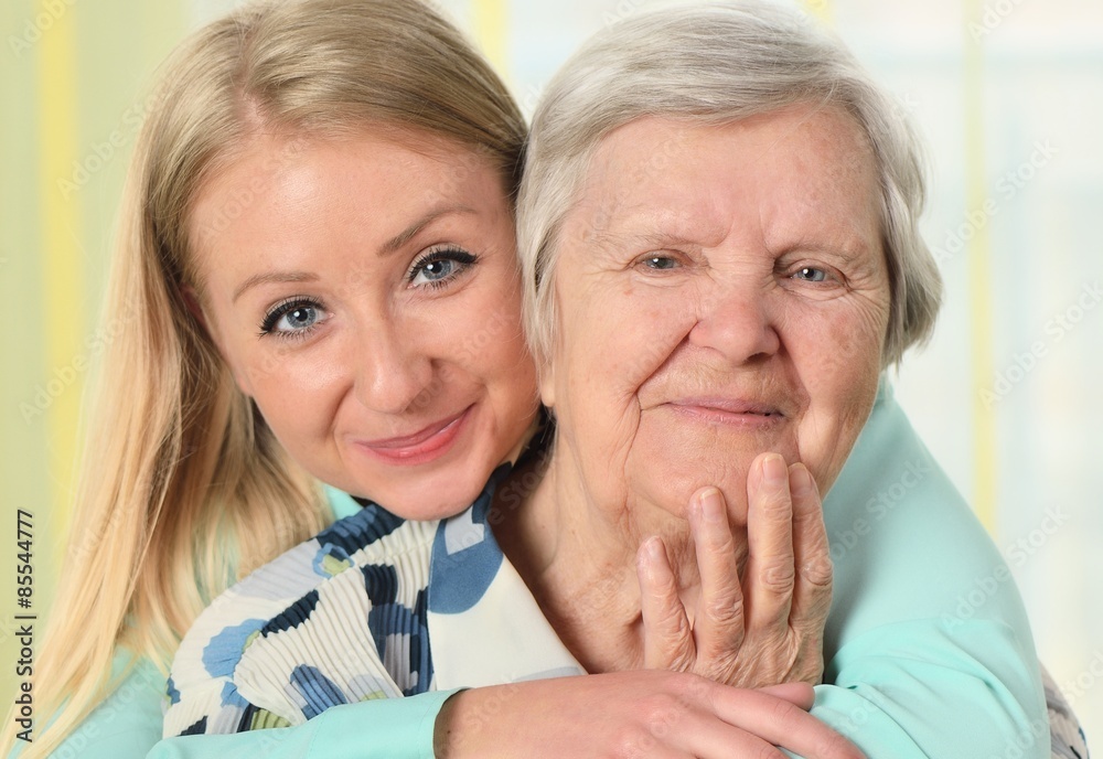 Senior woman with her caregiver. Happy and smiling.