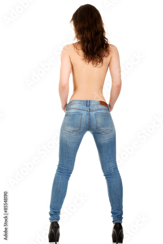 Shirtless woman alluring in jeans.