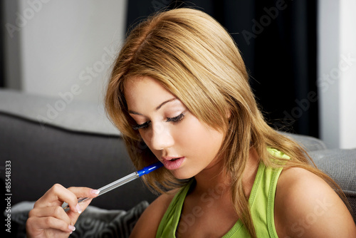 Young woman learning to exam on a sofa.