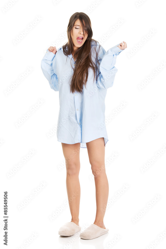 Young yawning woman in big shirt.
