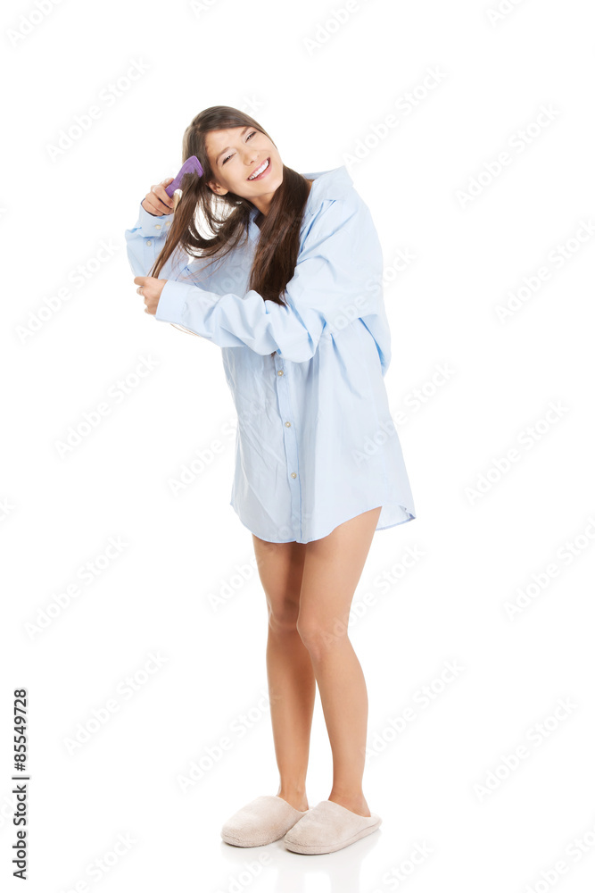 Morning woman in big shirt combing hair. Morning woman in big shirt combing hair.
