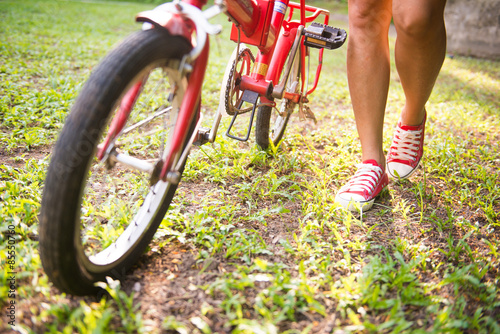 girl is holding bicycles in park