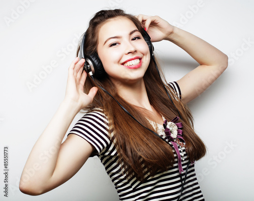 Young happy woman with headphones listening music 