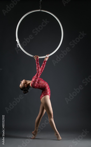 Studio shot of graceful acrobat performs with hoop