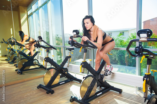 Beautiful woman at the gym on bike, cycle, sunny gym, general